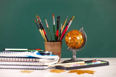 Okul malzemeleri hafif arka planda bir kompozisyonda sergilenir. Okula geri dön..