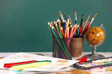 Okul malzemeleri hafif arka planda bir kompozisyonda sergilenir. Okula geri dön..