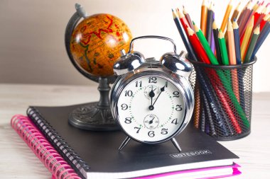 Okul malzemeleri hafif arka planda bir kompozisyonda sergilenir. Okula geri dön..