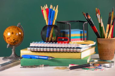 Okul malzemeleri hafif arka planda bir kompozisyonda sergilenir. Okula geri dön..