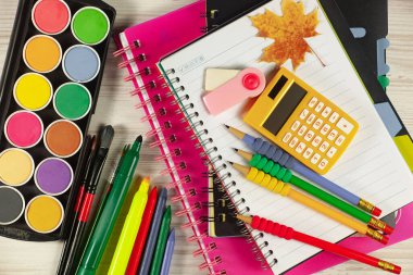 Okul malzemeleri hafif arka planda bir kompozisyonda sergilenir. Okula geri dön..