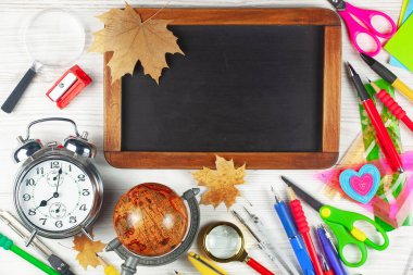 Okul malzemeleri hafif arka planda bir kompozisyonda sergilenir. Okula geri dön..