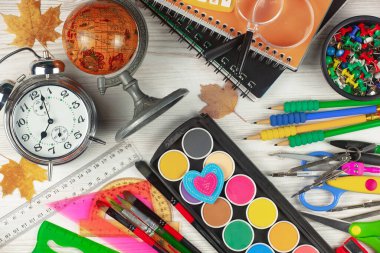 Okul malzemeleri hafif arka planda bir kompozisyonda sergilenir. Okula geri dön..