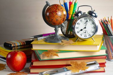 Okul malzemeleri hafif arka planda bir kompozisyonda sergilenir. Okula geri dön..