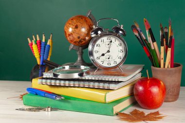 Okul malzemeleri hafif arka planda bir kompozisyonda sergilenir. Okula geri dön..