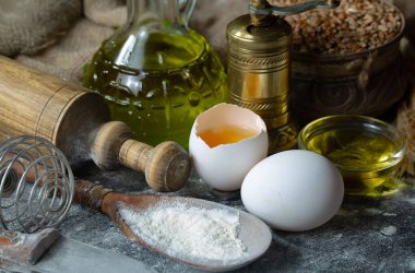 Eski bir arka planda un ve yumurtalarla hamur yoğurmak