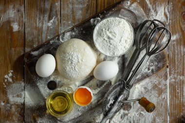 Eski bir arka planda un ve yumurtalarla hamur yoğurmak