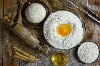 Eski bir arka planda un ve yumurtalarla hamur yoğurmak
