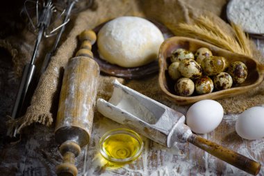 Eski bir arka planda un ve yumurtalarla hamur yoğurmak