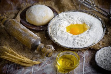 Eski bir arka planda un ve yumurtalarla hamur yoğurmak