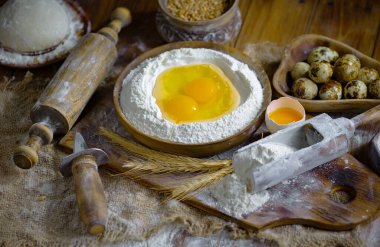 Eski bir arka planda un ve yumurtalarla hamur yoğurmak