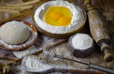 Eski bir arka planda un ve yumurtalarla hamur yoğurmak