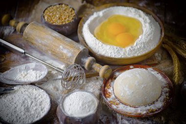 Eski bir arka planda un ve yumurtalarla hamur yoğurmak