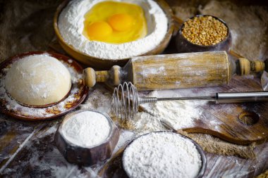 Eski bir arka planda un ve yumurtalarla hamur yoğurmak