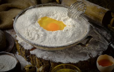 Eski bir arka planda un ve yumurtalarla hamur yoğurmak