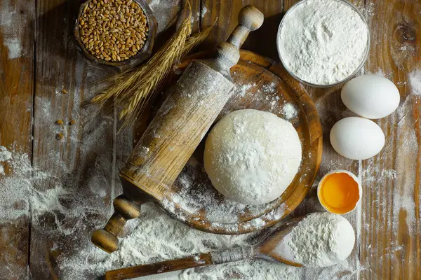 Eski bir arka planda un ve yumurtalarla hamur yoğurmak