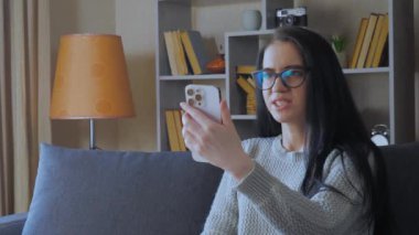 Genç ve güzel bir kız, uzun siyah saçlı gözlük takıyor, telefonda bir arkadaşıyla duygusal iletişim kuruyor, haklı olduğunu kanıtlıyor, duygusal olarak hareket ediyor ve güçlü olduğunu gösteriyor. 