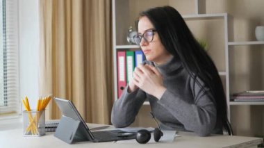 Genç ve güzel bir kız öğrenci, gözlük ve kulaklık takıyor, evde, masada oturuyor, uzaktan çalışıyor. O yorgun ve uykuya dalar. Yavaş çekim.