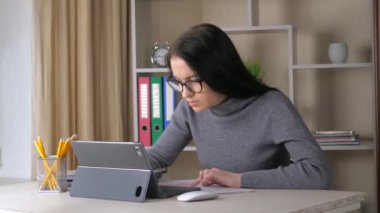 Gri bluzlu, koyu renk saçlı güzel bir kız, bir iş projesiyle ilgili verileri doğruluyor, belgeden bilgisayara aktarıyor. Yavaş Hareket