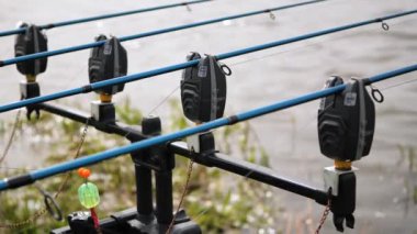 Doğada dönen makaralı oltalar ve dönen çubuklar, yakın çekim. Yaz, güzel hava, nehir. Yavaş çekim.