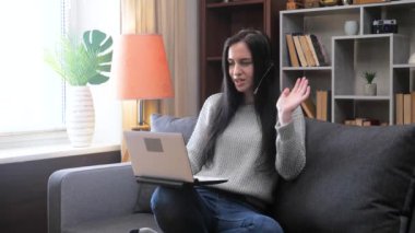 Genç, güzel iş kadını çalışıyor, bilgisayar teknolojisi kullanıyor, evde otururken internet sayfalarını karıştırıyor, iş raporlarında düzeltmeler yapıyor ve düzeltmeler yapıyor..