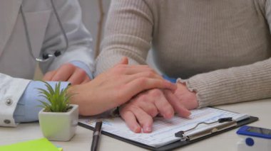 Ofiste genç bir doktor, orta yaşlı, engelli, parmakları olmayan bir kadını kabul ediyor, sağlık durumunu açıklıyor, teşhis koyuyor, uygun tedaviyi yazıyor ve hastaya manevi destek sağlıyor. Yavaş çekim.