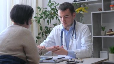 Ofiste genç bir doktor, orta yaşlı, engelli, parmakları olmayan bir kadını kabul ediyor, sağlık durumunu açıklıyor, teşhis koyuyor, uygun tedaviyi yazıyor ve hastaya manevi destek sağlıyor. Yavaş çekim.
