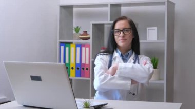 Genç, güzel bir laboratuvar asistanı, steteskoplu tıbbi bir önlükle, analiz için bir hastadan alınan kana bakar ve hangi tedaviyi yazacağına karar verir. Yavaş çekim.