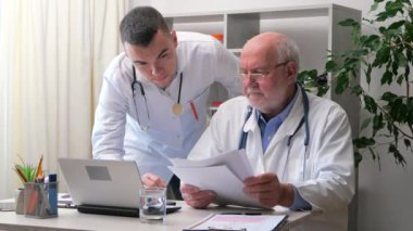 Ofiste yaşlı bir doktor, genç bir stajyer doktorla konuşuyor, hastanın durumunu ve tedavisini tartışıyor, tartışma yoluyla teşhis ve reçeteli ilaçlar konusunda fikir birliğine varıyorlar..