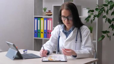 Genç bir kadın, bir doktor, ampulleri masaya yatırılmış tıbbi hazırlıklarla inceliyor. - Evet. Yavaş çekim.