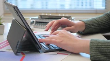 Ofiste, iş yapmak için gerekli eşyalarla birlikte bir kadının ellerini yakın plan çekeceğiz. Bir kız, bir hesap makinesi ve bilgisayar kullanarak, küresel bir mali raporun verilerini hesaplıyor. Yavaş çekim.