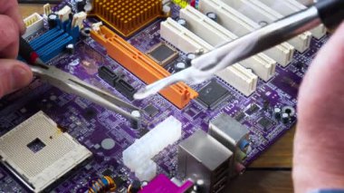 Atölyedeki ana kartı tamir et. Ustanın elleri, kullanım sürecindeki arızalar nedeniyle elektronik aletleri tamir edecek şekilde yakın plan çekimde. Yakın plan. Yavaş çekim.