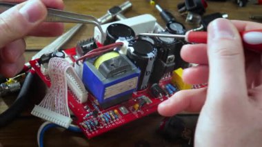 Atölyedeki ana kartı tamir et. Ustanın elleri, kullanım sürecindeki arızalar nedeniyle elektronik aletleri tamir edecek şekilde yakın plan çekimde. Yakın plan. Yavaş çekim.