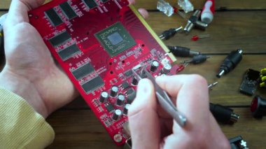 Atölyedeki ana kartı tamir et. Ustanın elleri, kullanım sürecindeki arızalar nedeniyle elektronik aletleri tamir edecek şekilde yakın plan çekimde. Yakın plan. Yavaş çekim.