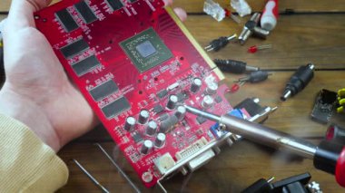 Atölyedeki ana kartı tamir et. Ustanın elleri, kullanım sürecindeki arızalar nedeniyle elektronik aletleri tamir edecek şekilde yakın plan çekimde. Yakın plan. Yavaş çekim.
