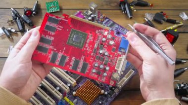 Atölyedeki ana kartı tamir et. Ustanın elleri, kullanım sürecindeki arızalar nedeniyle elektronik aletleri tamir edecek şekilde yakın plan çekimde. Yakın plan. Yavaş çekim.
