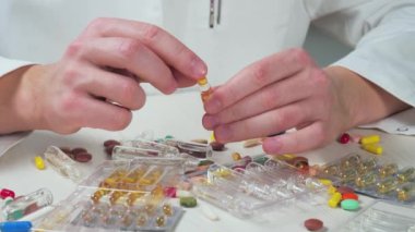 Genç doktor ampul içinde bir ilaç üzerinde çalışıyor. Eller yakın çekim. Yavaş çekim.