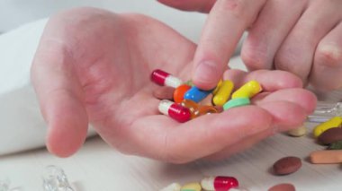 Avucunun içinde hapları inceleyen genç bir doktor. Elleri yakın çekim. Yavaş çekim.