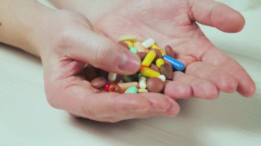 Genç bir doktor hapları muayene edip avucuna atıyor. Yakın plan. Yavaş çekim.