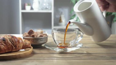 Yaşlı bir adam kahve makinesinden bir fincana kahve doldurur. Yakın plan. Yavaş çekim.