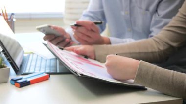 Finansal bir rapor hazırlamak için birlikte çalışan genç muhasebeciler. Yakın plan. Yavaş çekim.