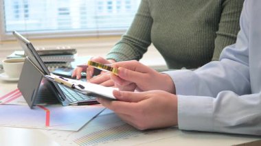 Finansal bir rapor hazırlamak için birlikte çalışan genç muhasebeciler. Yakın plan. Yavaş çekim.