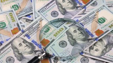 Amerikan doları, yavaşça dönüyor. Ay yukarıdan gelen banknotların üzerine düşüyor. Üst Manzara. Yavaş çekim.