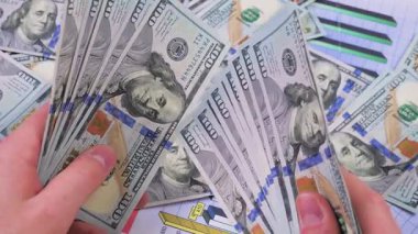 Genç bir finansörün elleri yavaş yavaş para, dolar kaydırıyor. Yavaş çekim.