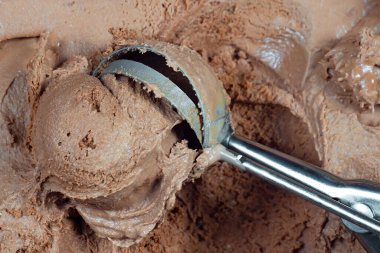 Bir kepçe çikolatalı dondurma ve yakından bir kepçe