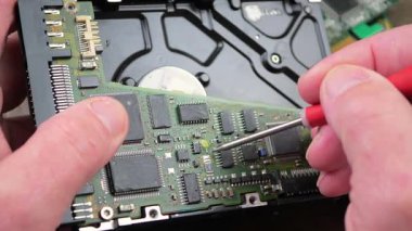 Atölyedeki ana kartı tamir et. Ustanın elleri, kullanım sürecindeki arızalar nedeniyle elektronik aletleri tamir edecek şekilde yakın plan çekimde. Yakın plan. Yavaş çekim.
