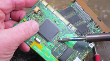 Atölyedeki ana kartı tamir et. Ustanın elleri, kullanım sürecindeki arızalar nedeniyle elektronik aletleri tamir edecek şekilde yakın plan çekimde. Yakın plan. Yavaş çekim.