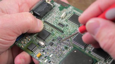 Atölyedeki ana kartı tamir et. Ustanın elleri, kullanım sürecindeki arızalar nedeniyle elektronik aletleri tamir edecek şekilde yakın plan çekimde. Yakın plan. Yavaş çekim.