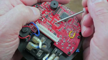 Atölyedeki ana kartı tamir et. Ustanın elleri, kullanım sürecindeki arızalar nedeniyle elektronik aletleri tamir edecek şekilde yakın plan çekimde. Yakın plan. Yavaş çekim.