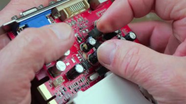 Atölyedeki ana kartı tamir et. Ustanın elleri, kullanım sürecindeki arızalar nedeniyle elektronik aletleri tamir edecek şekilde yakın plan çekimde. Yakın plan. Yavaş çekim.